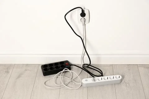Extension cords with power plugs in socket indoors. Electrician's professiona Stock Photos