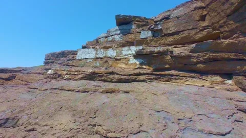 Extensive rocky shoreline flat overlooking blue sea Stock Footage 340451290