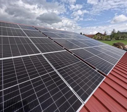 Extensive Solar Panel Array on the Metal Roof of a Large Industrial Facility Foto stock