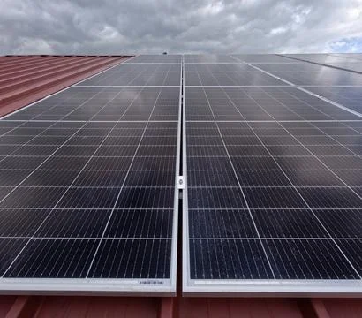 Extensive Solar Panel Array on the Metal Roof of a Large Industrial Facility 写真素材