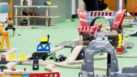 Extensive wooden toy train set layout on green mat. Network of curved and Stock Footage 340386701