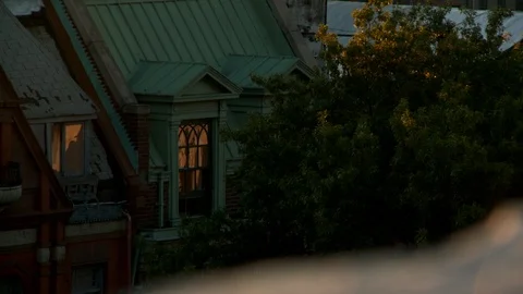 Exterior apartment with lights on inside &amp; tree branches swaying in breeze, day. Vídeo Stock 111024791