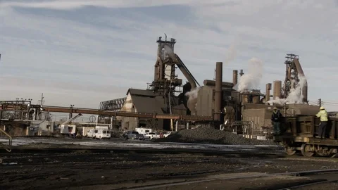 Exterior Factory - 2 Men on Train car in Foreground Stock Footage 89980662