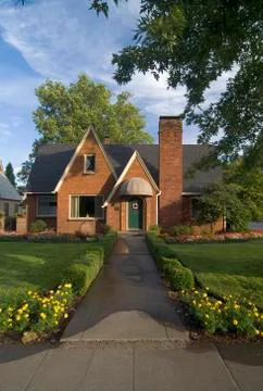 Exterior front view of red brick cottage with landscaping at Chico Stock Photos