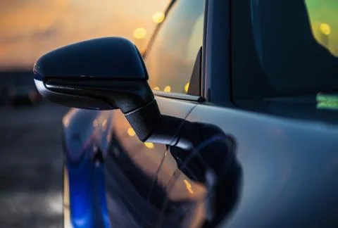 Exterior Right Side View Mirror And Cover Of Blue Sports Car On Road At Dusk. Stock Photos