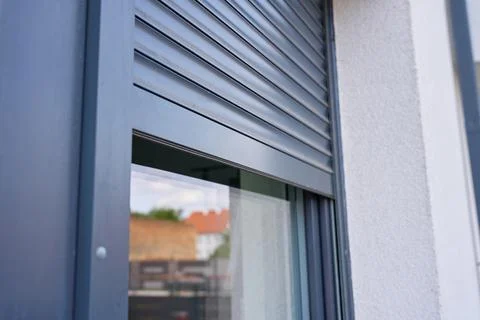 Exterior roller shutter covers the upper part of house window beside white fa Stock-Fotos