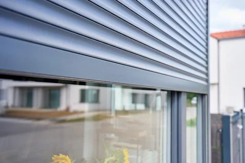 Exterior roller shutter is lowered over the upper part of modern residential Stock Photos