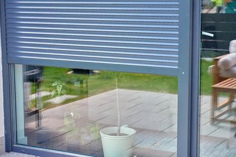 Exterior roller shutter partially open on patio window Stock Photos