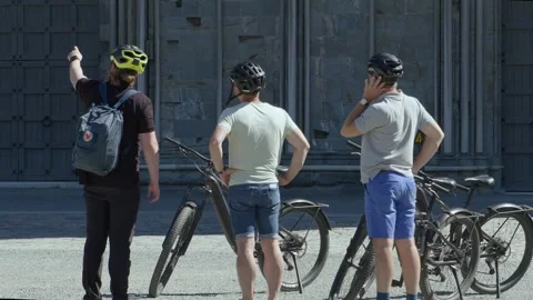 Exterior shot of tourists on e-bikes outside of the Nidarosdomen cathedral Stock Footage 246181589