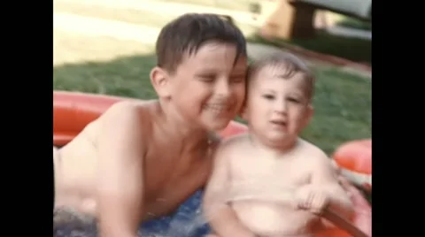 Exterior summer backyard inflatable pool with toddler and 8 year old brother Video stock 48222679