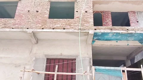 Exterior view of building under construction with bamboo scaffolding Vídeos de archivo 338250856