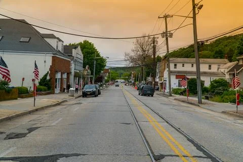 Exterior view down generic main street in small town USA as sunrise comes ove Stock Photos
