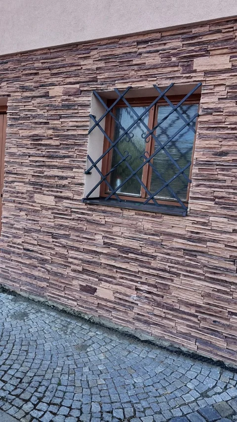 Exterior view of a house with stone facade and wooden garage doors Stock Footage 341525831