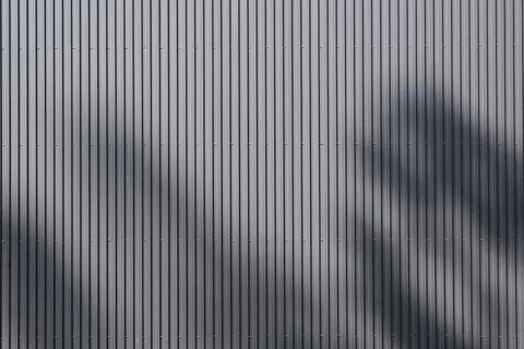Exterior wall with symmetrical parallel lines design and shadow 스톡 사진