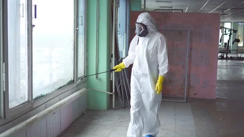Exterminator in overalls and a protective mask carries out processing of the Stock Footage 105685464