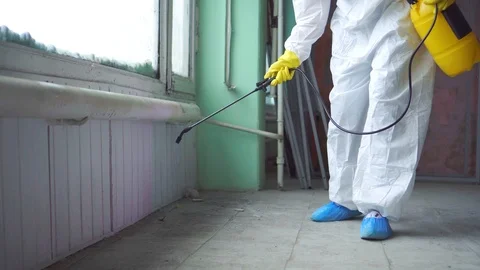 Exterminator in overalls carries out processing of the room from a mold Stock Footage 105610299
