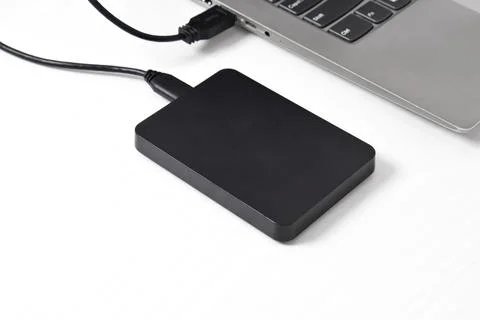 External backup hard disk drive connected to laptop on white background Stock Photos
