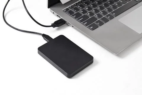 External backup hard disk drive connected to laptop on white background Stock Photos