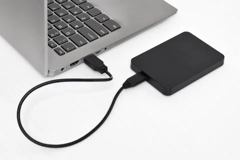 External backup hard disk drive connected to laptop on white background Stock Photos