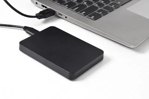 External backup hard disk drive connected to laptop on white background Stock Photos