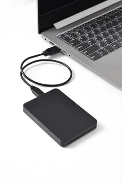 External backup hard disk drive connected to laptop on white background Stock Photos