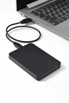 External backup hard disk drive connected to laptop on white background Stock Photos