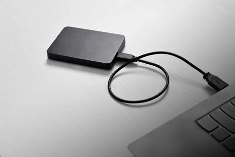 External backup hard disk drive connected to laptop on white background Stock Photos