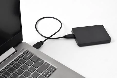 External backup hard disk drive connected to laptop on white background Stock Photos