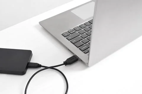 External backup hard disk drive connected to laptop on white background Stock Photos