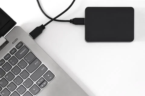 External backup hard disk drive connected to laptop on white background Stock Photos