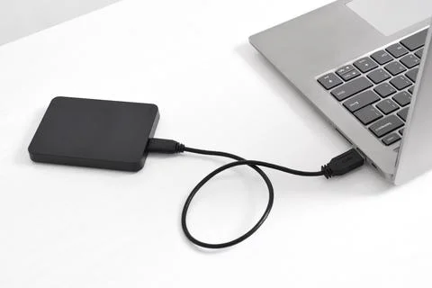 External backup hard disk drive connected to laptop on white background Stock Photos