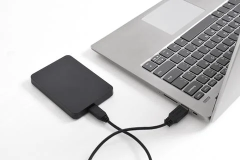 External backup hard disk drive connected to laptop on white background Stock Photos