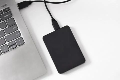 External backup hard disk drive connected to laptop on white background Stock Photos
