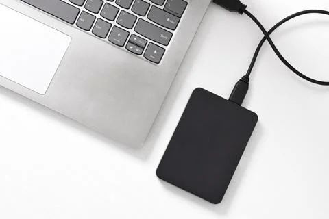 External backup hard disk drive connected to laptop on white background Stock Photos