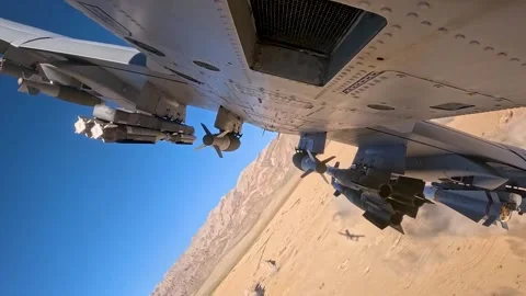External camera footage of A-10 Thunderbolt firing gattling gun flying in desert Stock Footage 280034720