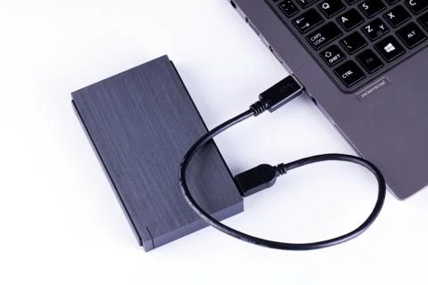 External hard disk connected to computer - notebook on white background. Stock Photos