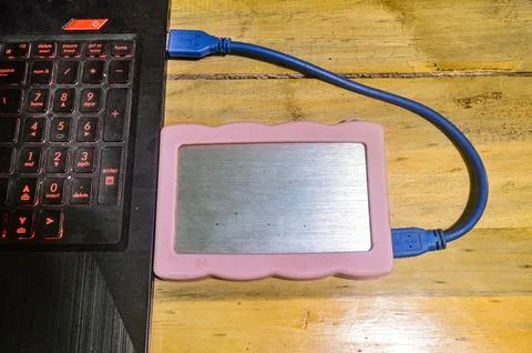 An external hard disk connected to a laptop using a USB cable Stock Photos