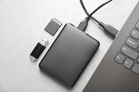 External hard disk connected to laptop, SD memory card and flash drive on g.. Stock Photos