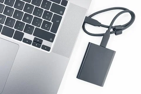 External hard disk connected to a modern laptop computer. Top view Stock Photos