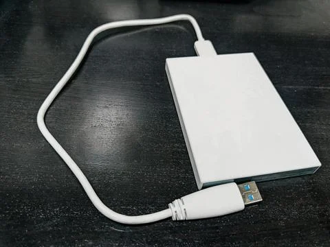 External Hard Disk Drive with Data Cable on the black wooden table Stock Photos