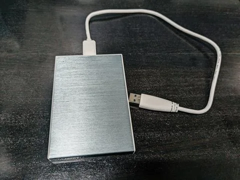 External Hard Disk Drive with Data Cable on the black wooden table Stock Photos