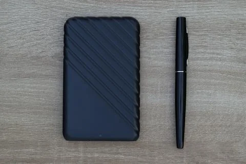 External hard drive and black pen on wooden surface Stock Photos