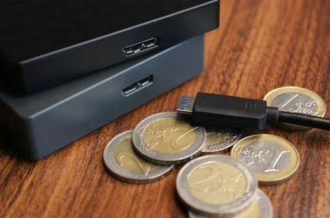 External hard drive with cable close-up. External hard drives and euro coins. Stock Photos