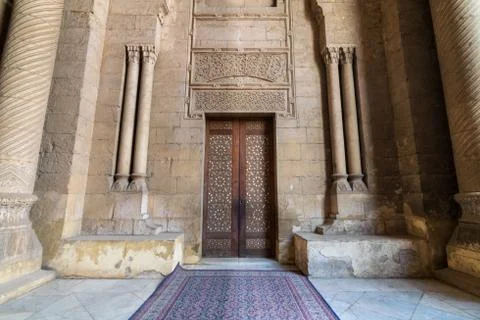External old decorated bricks stone wall with arabesque decorated wooden door Stock Photos
