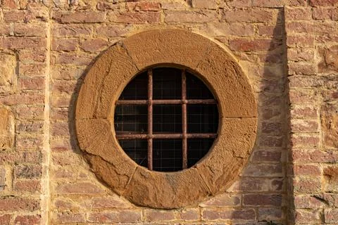 External round window with bars on medieval castle in Tuscany Italy Stock Photos