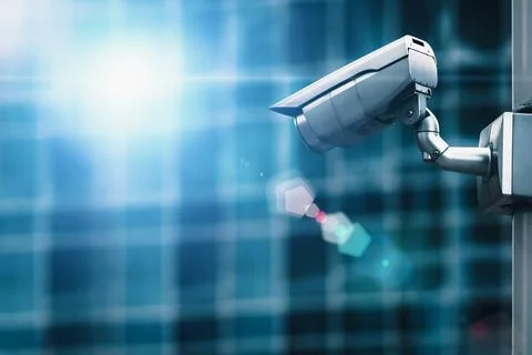 External security camera on pole in front of glass building wall Stock Photos