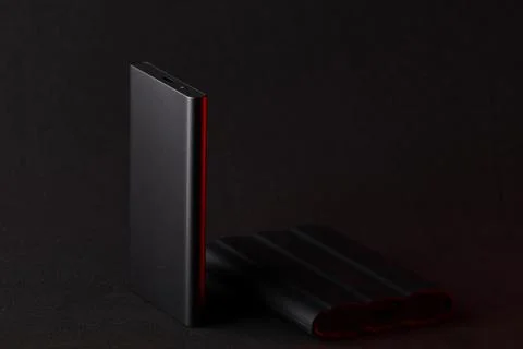 External SSD drive with red light reflection on dark background Stock Photos