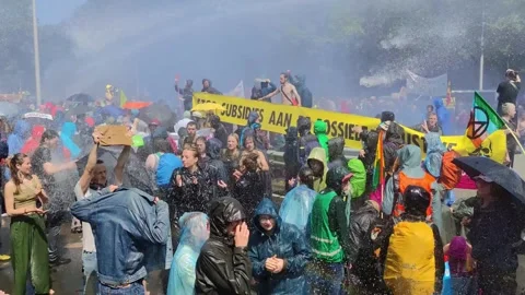 Extinction Rebellion activists blocking the road, police using water cannon 스톡 동영상 242274694