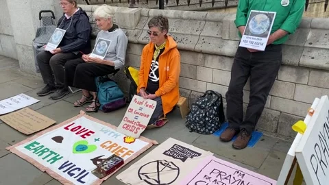 Extinction Rebellion protesters praying for action on the climate crisis. Stock Footage 246501664