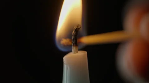 Extinguished candle black background closeup. Hand holding wooden match sparking Stock Footage 332506676